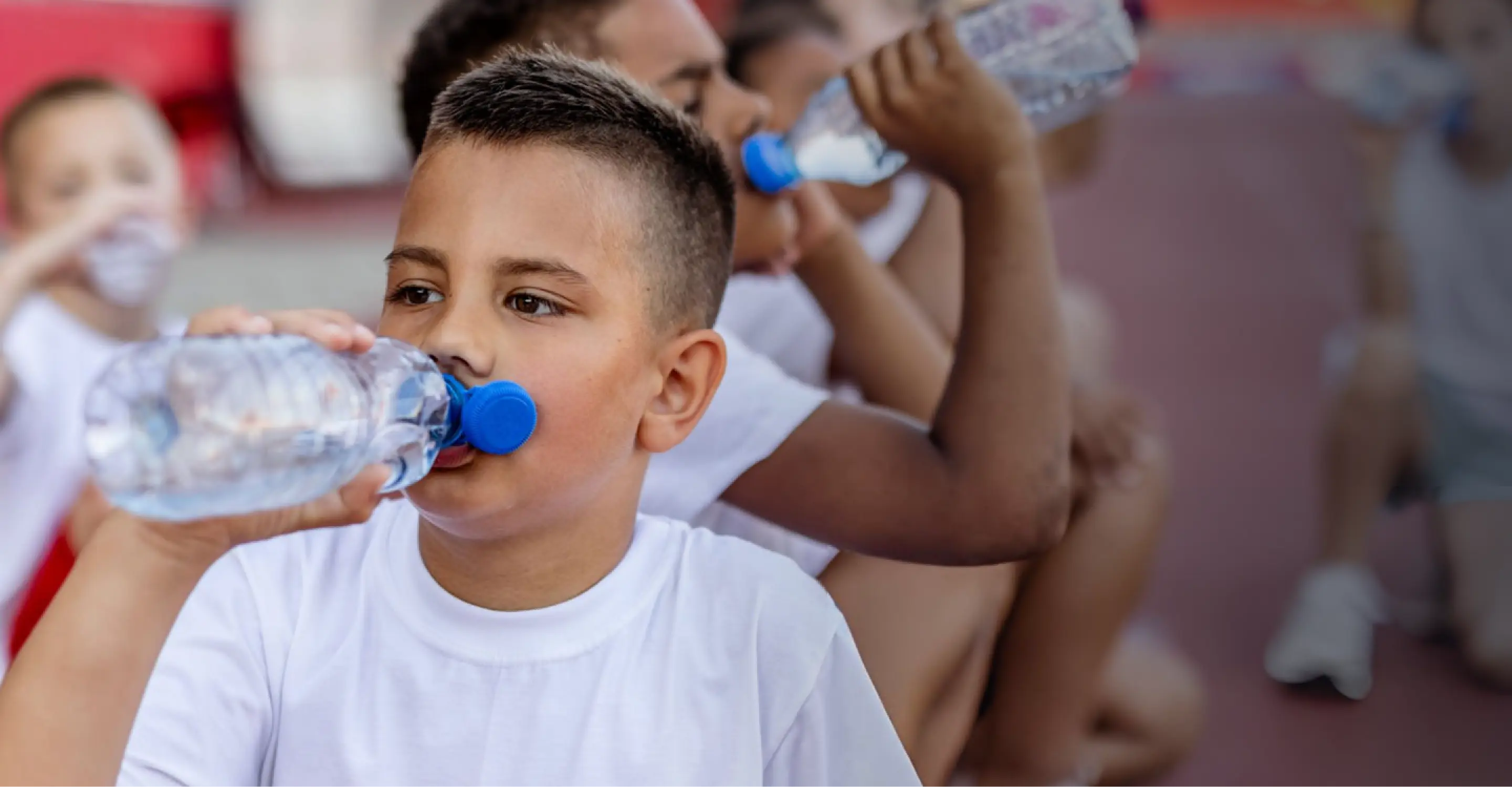 A group of young boys drinking water
